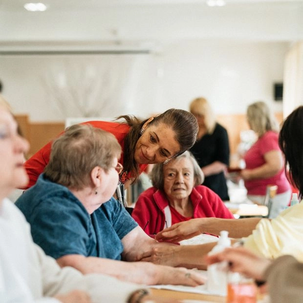 Caregivers laughing with senior clients around a table